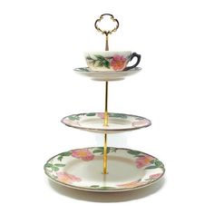 three tiered tray with two cups and saucers on each plate, one has a gold ring at the top