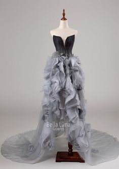 a dress on a mannequin with grey ruffles and black trimming