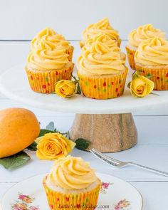 tropical mango vanilla cupcakes with orange frosting on a white cake platter