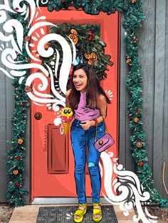 a woman standing in front of a red door