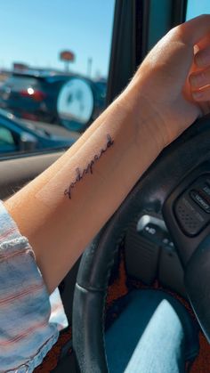 a person with a tattoo on their arm driving a car