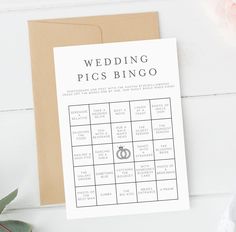 a card with a wedding pics bingo on it next to flowers and a plant