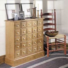 a wooden dresser sitting next to a chair in a room