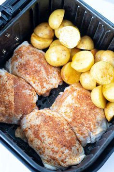 some chicken and potatoes in a black container