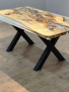 a wooden table sitting on top of a hard wood floor next to a white wall