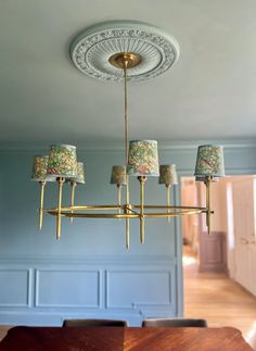 a chandelier hanging from the ceiling in a room with blue walls and wooden floors