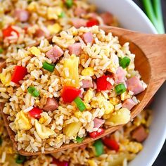 rice with ham and green onions in a white bowl on top of chopsticks