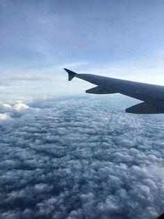 the wing of an airplane flying high above the clouds