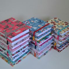 a stack of books sitting next to each other on top of a white tablecloth