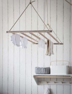 clothes hanging from a wooden hanger in a white room