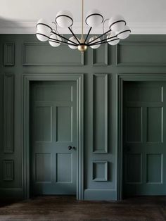 an empty room with green walls and doors