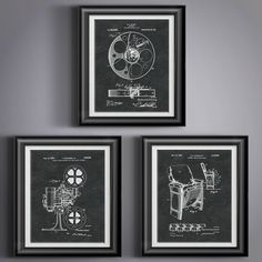 three framed photographs of film reels on a gray wall with black frame and white trim