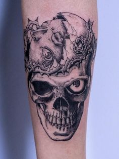 a black and white photo of a skull with roses on it's head tattoo