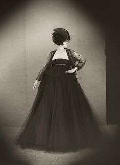 an old fashion photo of a woman in a black dress