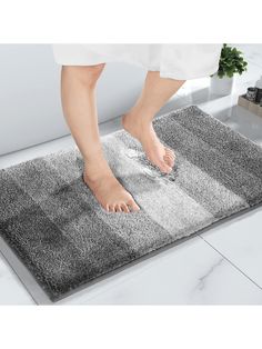 a person standing on top of a bathroom rug