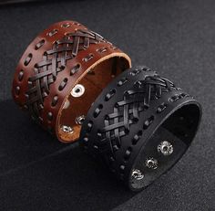 two leather bracelets with skulls and crosses on the inside, one is black and one is brown