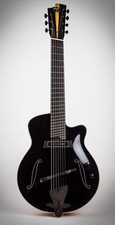 an electric guitar with a black body and yellow frets on it's neck