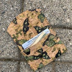 a wallet sitting on top of a sidewalk next to a brick wall and cement floor