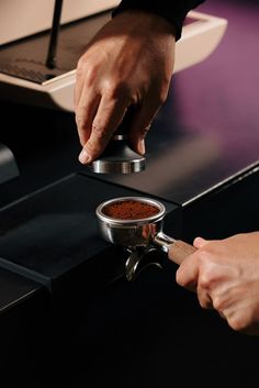 a person is using a spice grinder to mix spices on a stove top burner