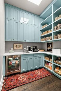 a kitchen filled with lots of blue cupboards and shelves next to a stove top oven