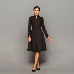 A beautiful structured dress featuring high neck collar, a-line silhouette, and long sleeves. - high neck (stand collar) - trapeze skirt with inverted front pleat  - long sleeves with elegant cuffs - knee length (midi) - a line silhouette - the dress is decorated with high-quality metal buttons  Perfect as party, modest bridesmaid or elegant office dress. Seasons: autumn, winter, spring. Color: Black  Fiber: viscose - 60%, elastan - 5%, polyester - 35%  Concealed back zipper closure For Size 2 U Yellow Wedding Guest Dresses, Elegant Purple Dresses, High Neck Black Dress, Stand Collar Dress, Little Black Cocktail Dress, Cocktail Dress Wedding Guest, Mandarin Collar Dress, High Neck Midi Dress, Elegant Cocktail Dress