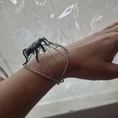 Embrace your edgy side with the Nocturnal Spider Cuff Bracelet, a bold statement piece perfect for the season of thrills and chills! Crafted from non-tarnish silver plated wire, this cuff bracelet features a striking black spider that brings a touch of punk and mystery to your look. Designed for both comfort and style, the cuff sits perfectly on your wrist without sacrificing ease of wear. Whether you're getting ready for a Halloween party or simply love the thrill of dark, daring accessories, t Black Claw-shaped Halloween Jewelry, Halloween Jewelry Gift With Claw Shape, Halloween Claw-shaped Jewelry Gift, Halloween Gift Jewelry With Claw Shape, Halloween Novelty Jewelry Bracelet, Halloween Novelty Bracelet, Black Metal Cuff Bracelet As Gift, Black Metal Cuff Bracelet For Gift, Edgy Bangle Jewelry Gift