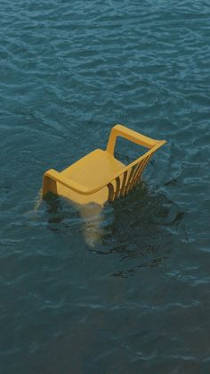 a yellow chair floating on top of water