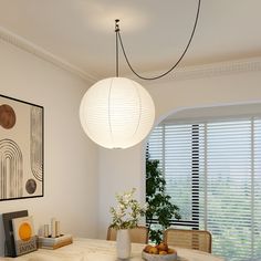 a dining room table with two chairs and a lamp hanging from the ceiling