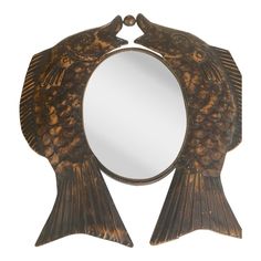 a fish shaped mirror sitting on top of a table