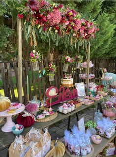 a wooden table topped with lots of cakes and cupcakes