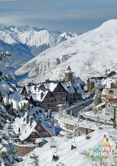 a ski resort in the mountains with snow on it's ground and trees covered in snow