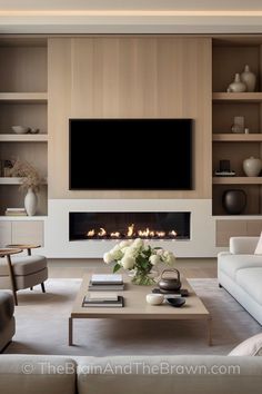 a living room with couches, tables and a television mounted on the wall above it