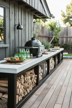 an outdoor bbq with food and drinks on the outside counter area, next to a wooden deck