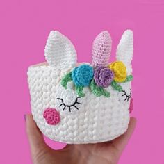 a small crocheted bunny purse with flowers on it's head and eyes