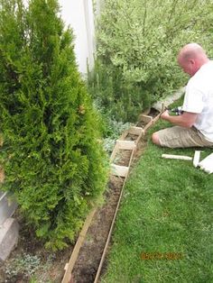 a man sitting on the ground working in his garden