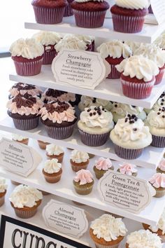 cupcakes are displayed on three tiered trays