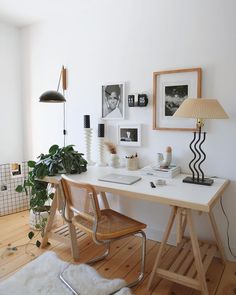 a white desk topped with a laptop computer next to a lamp and potted plant