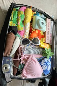 an open suitcase filled with clothing and toys