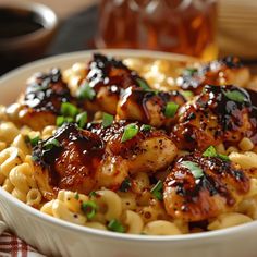 a white bowl filled with pasta covered in sauce and chicken wings on top of it