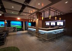 a bar with lots of stools in front of two large windows that look out onto the golf course