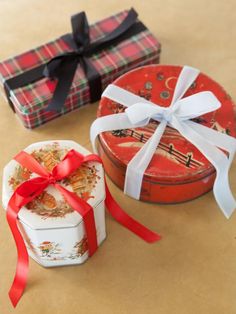 two small boxes with ribbons tied around them on a table next to some other items