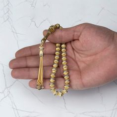 Experience the beauty and elegance of the Gold Plated Sterling Silver 33 Beads Clear Zirconia Tasbih Rosary Muslim Prayer Beads. Each bead boasts a diameter of 7.85 mm, and the total weight of the misbaha is 53.00 gr / 1.86 oz, making it the perfect weight for comfortable handling during prayer. The length of the misbaha is 9.5 inches, making it a convenient size for carrying with you wherever you go. Crafted with exquisite attention to detail, this misbaha features clear zirconia beads that add Traditional Gold Beaded Rosary, Elegant Beaded Rosary With Round Beads, Elegant Beaded Rosary, Adjustable Gold Rosary Traditional Style, Adjustable Gold Traditional Rosary, Rosary Prayer, Muslim Prayer, Sterling Silver Filigree, Silver Filigree