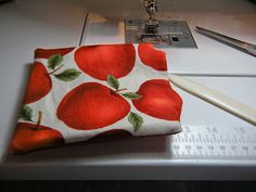 an apple print pouch sitting on top of a sewing machine