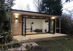 a home gym built into the side of a wooden building with lights on it's windows