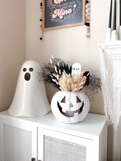 a white cabinet topped with halloween decorations and a jack - o'- lantern decoration