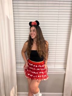 a woman in a minnie mouse costume standing next to a window with her hands on her hips