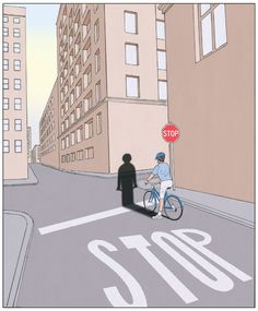 a man riding a bike down a street next to a stop sign and tall buildings