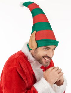 a man in a santa suit is smiling and wearing a hat with an elf's ears