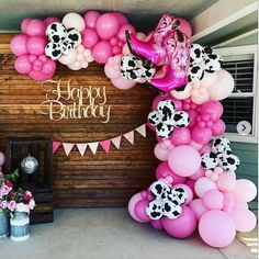 a birthday party with pink and white balloons, cowgirl decorations, and streamers