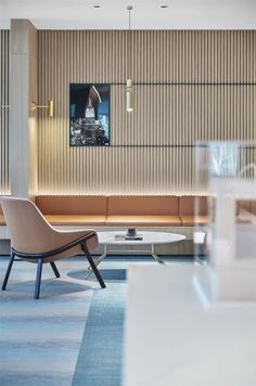 a living room filled with furniture next to a wall covered in wooden slatted panels